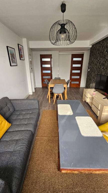 a living room with a couch and a table at T3 idéalement situé in Mérignac