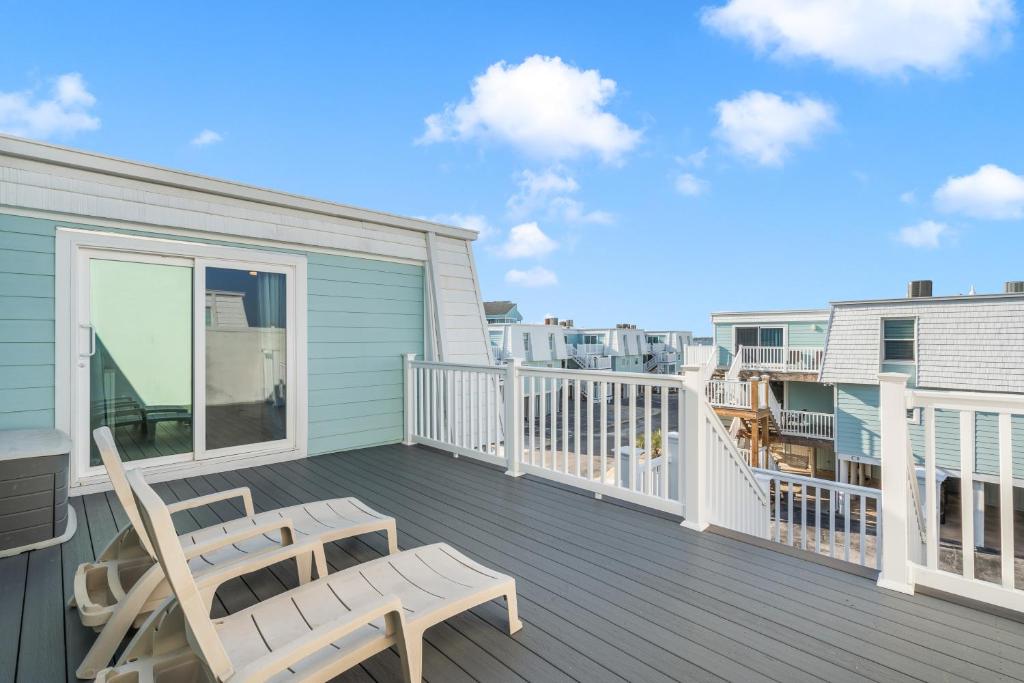 a balcony with two chairs and a table on it at Boardwalk Unit A18 in Pensacola Beach