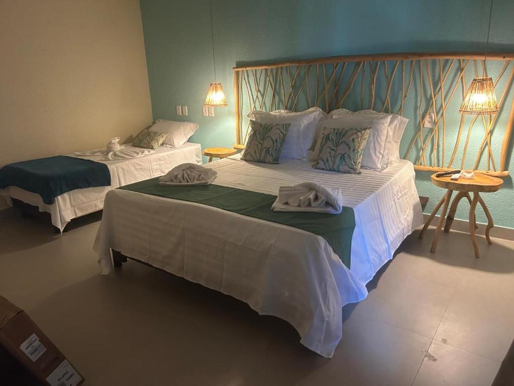 a bedroom with two beds with towels on them at Pousada Verdes dos Corais in São Miguel dos Milagres