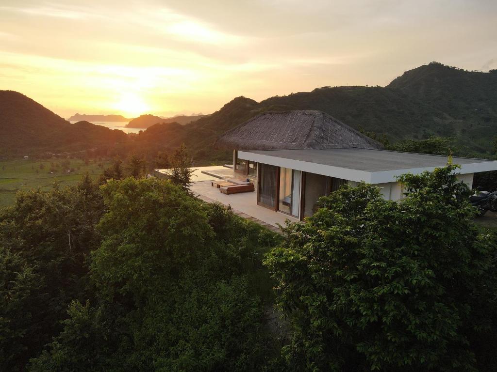 a house in the mountains with the sunset in the background at SABA Lombok in Selong Belanak