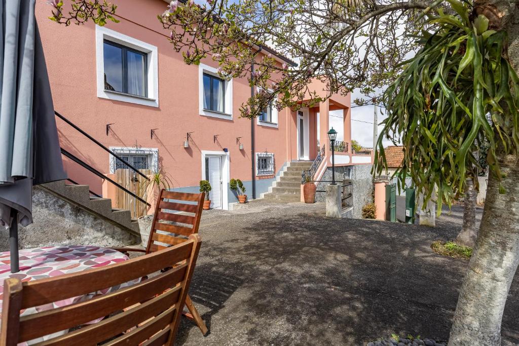 a bench in front of a pink building at A Quintinha by YOUR KEY MADEIRA in Santa Cruz