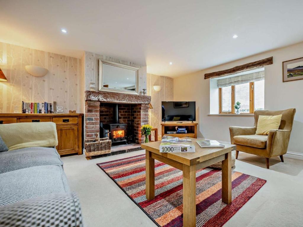 a living room with a couch and a fireplace at 3 Bed in Wigton oc-92826 in Torpenhow