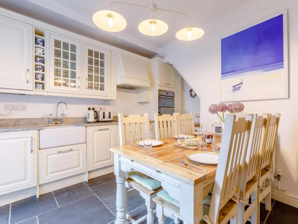 a kitchen with a wooden table and some chairs at 3 Bed in Bideford oc-57804 in Appledore