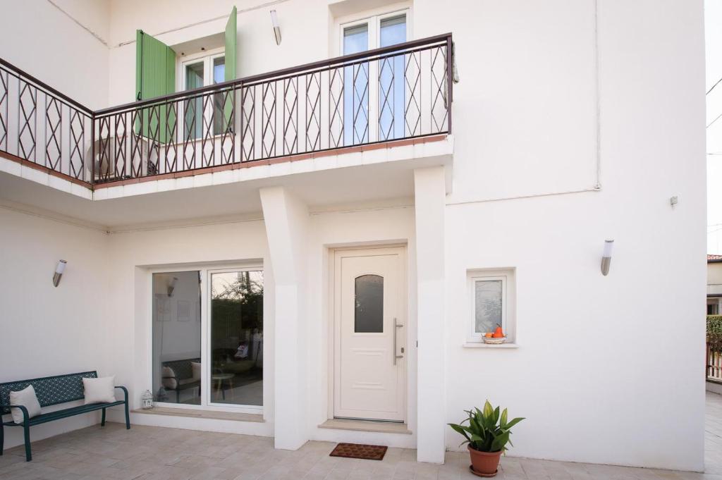 a white house with a balcony and a white door at Me amìa in Dolo