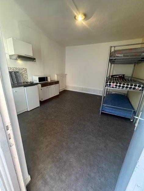 an empty room with a kitchen and a shelf in it at Dortoir Entier Privatif in Tarbes