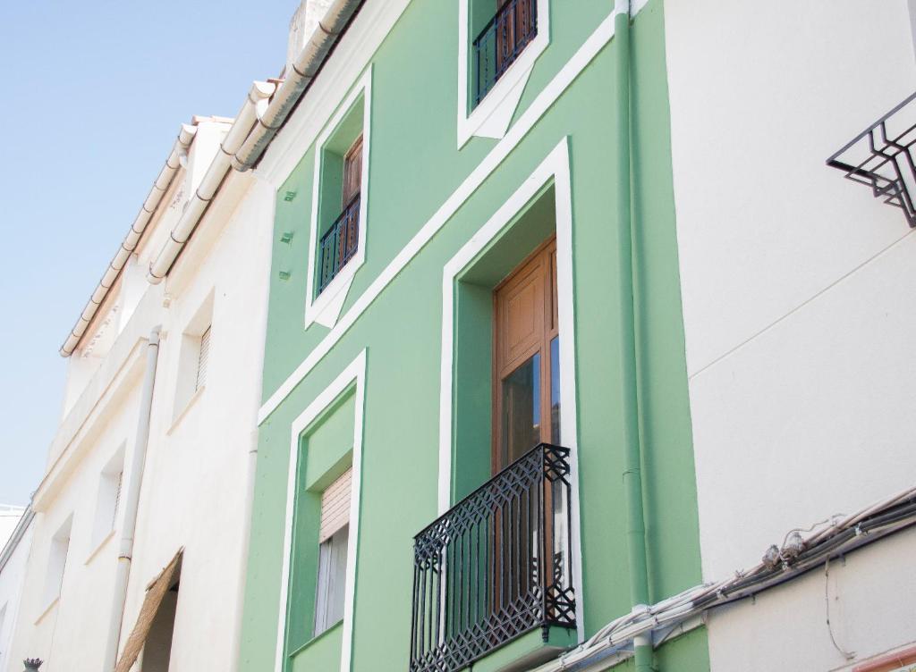 un edificio verde y blanco con balcón en Casa Marifina, en Enguera