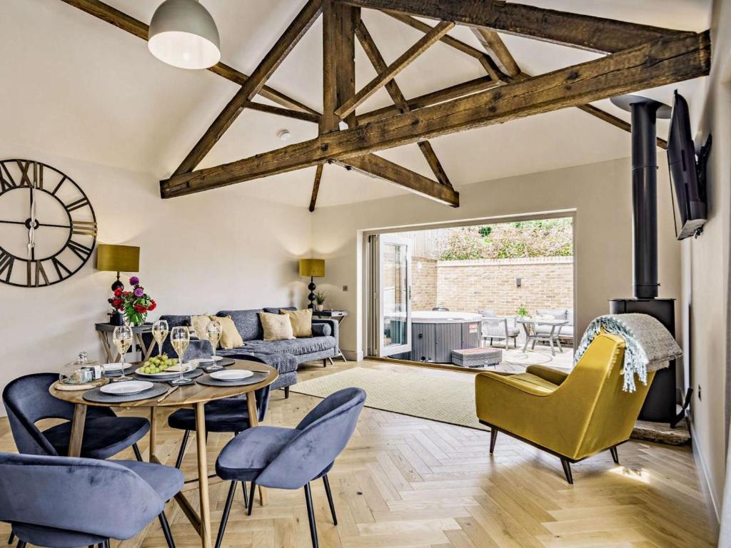a living room with a table and chairs and a clock at 2 Bed in Driffield oc-88238 in Lund