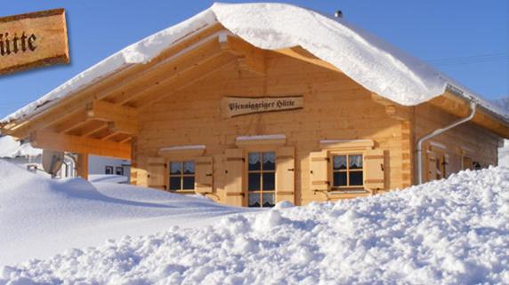 um edifício coberto de neve com uma pilha de neve em Pfenniggeiger-Hütte em Philippsreut