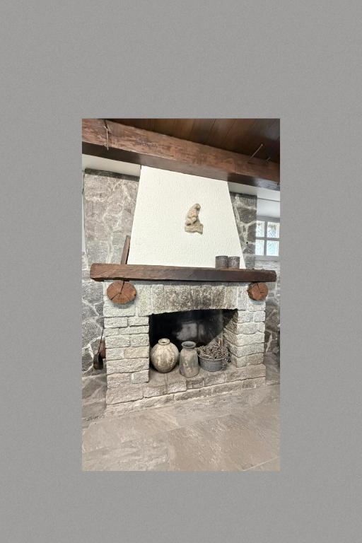 ein steinerner Kamin mit einem Schild darauf in der Unterkunft Schmuckes Rustico in Pianezzo