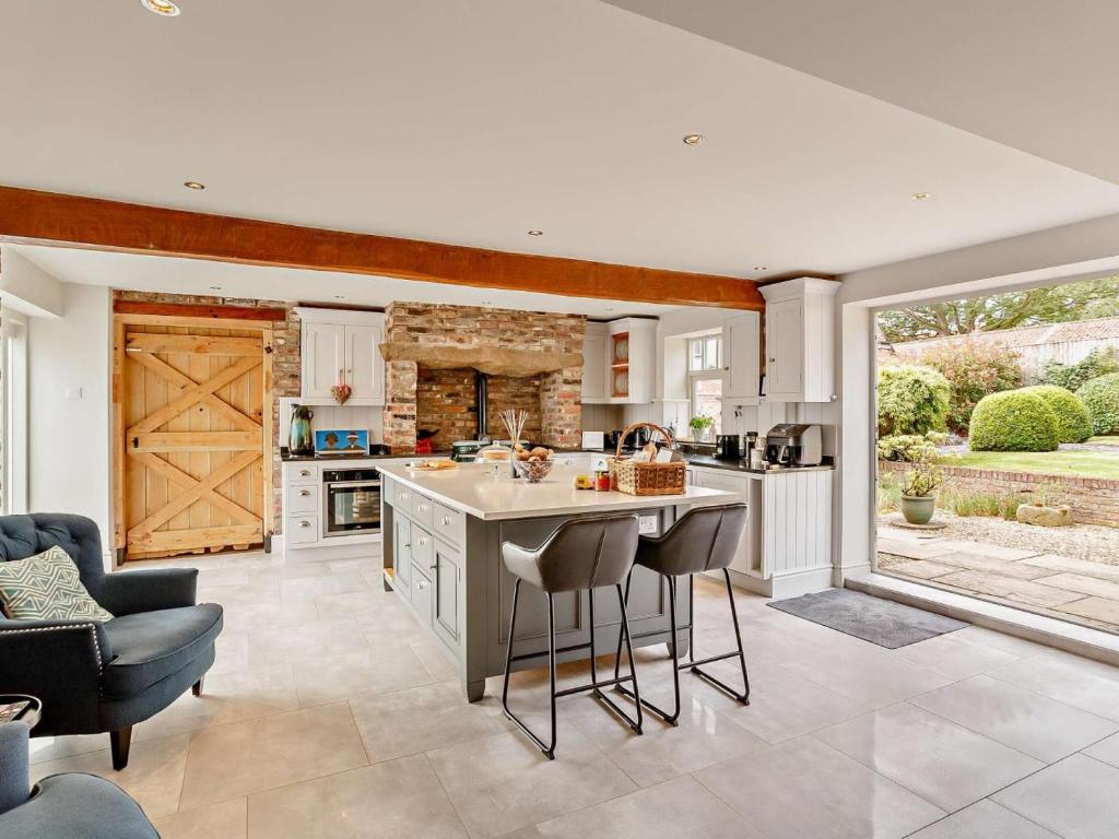 a kitchen with an island with stools in it at 3 Bed in Driffield oc-92697 in Lund