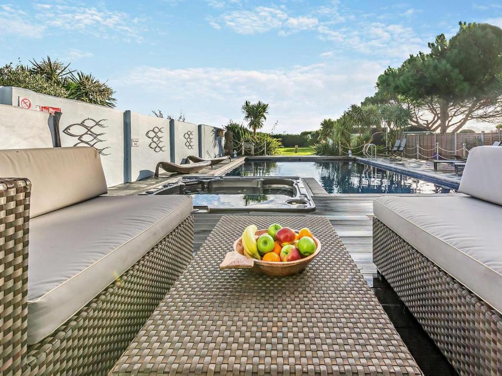 a bowl of fruit sitting on a table next to a pool at 4 Bed in Bognor Regis oc-81446 in Bognor Regis