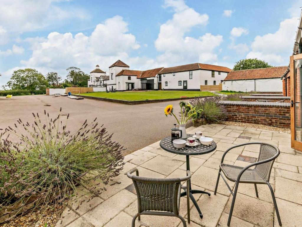a patio with a table and chairs and a house at 1 Bed in Doncaster oc-93572 in Mattersey