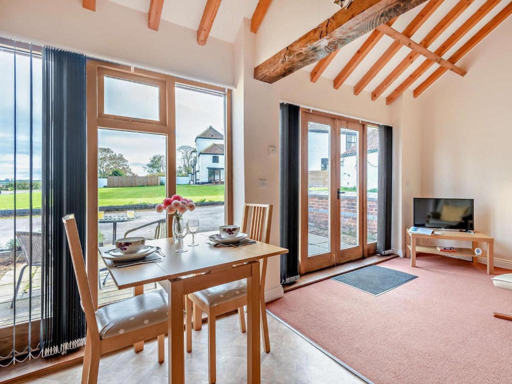 a dining room with a table and chairs and a television at 1 Bed in Doncaster oc-93571 in Mattersey