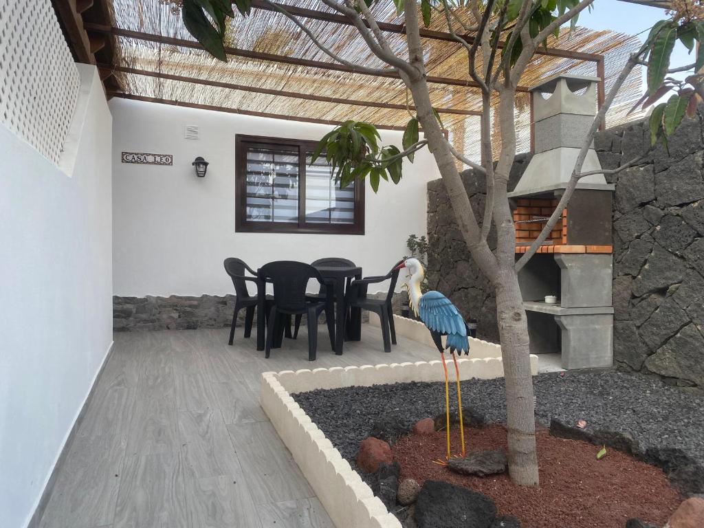 a patio with a table and chairs and a bird statue at Apartamento Casa Leo in Playa Blanca