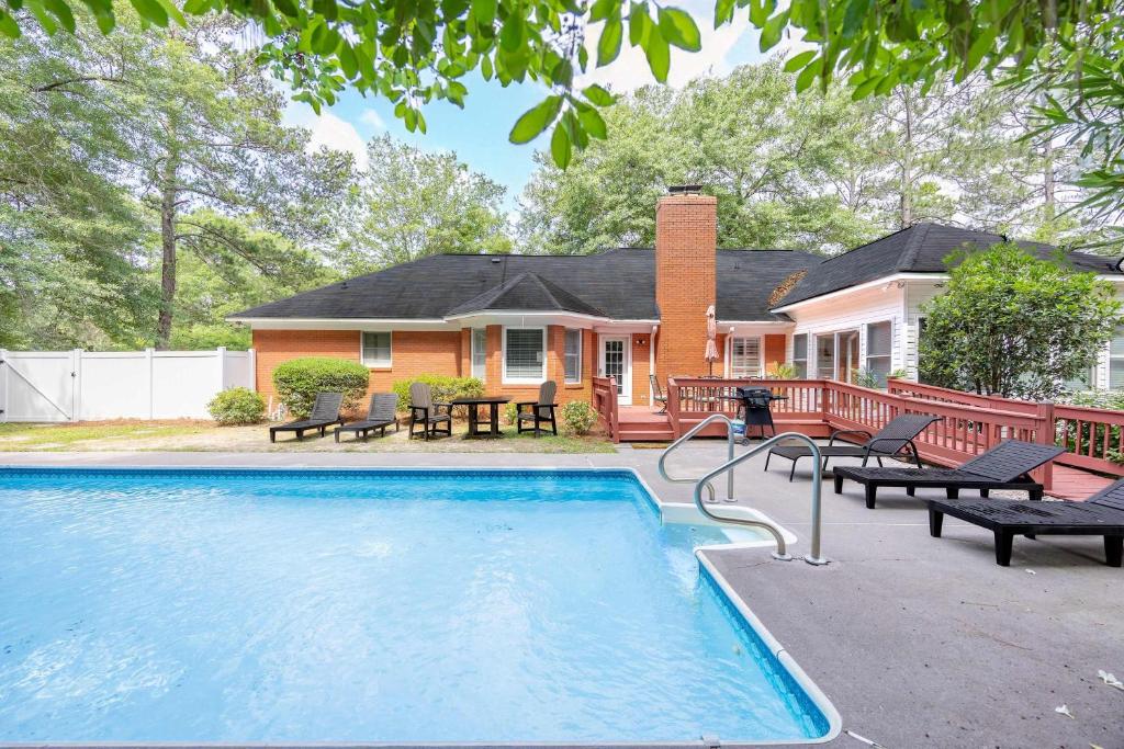 a house with a swimming pool in front of a house at Market District Pool House in Statesboro