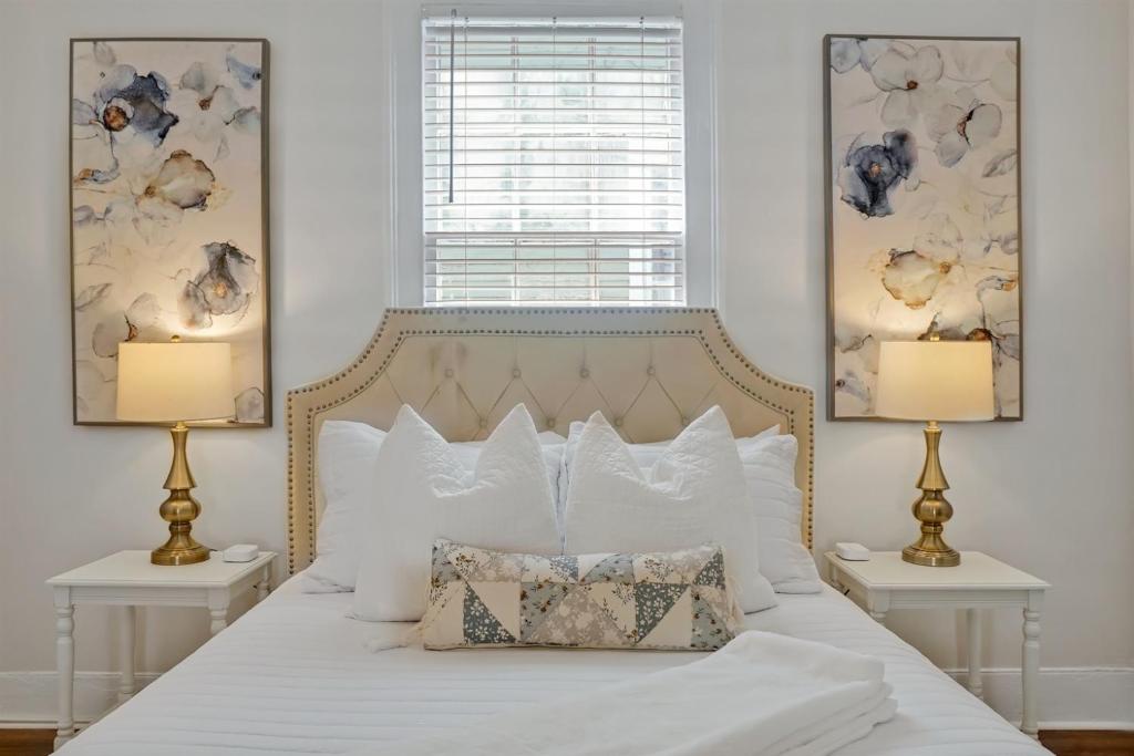 a bedroom with a white bed with two lamps at Downtown Bliss in Wilmington
