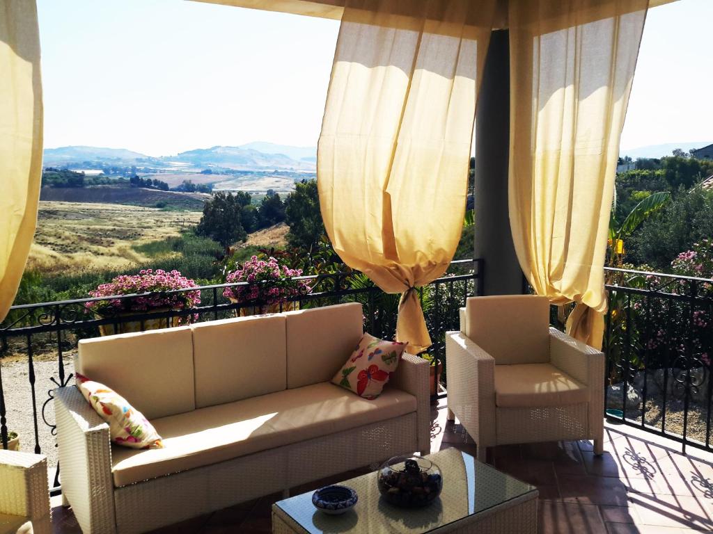 d'un salon avec un canapé et des chaises sur un balcon. dans l'établissement Villa Montalbano, à Villaggio Mosè