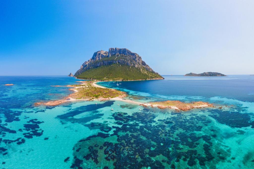 an island in the ocean with blue water at Costa Corallina Villa with direct beach access and stunning views in Costa Corallina