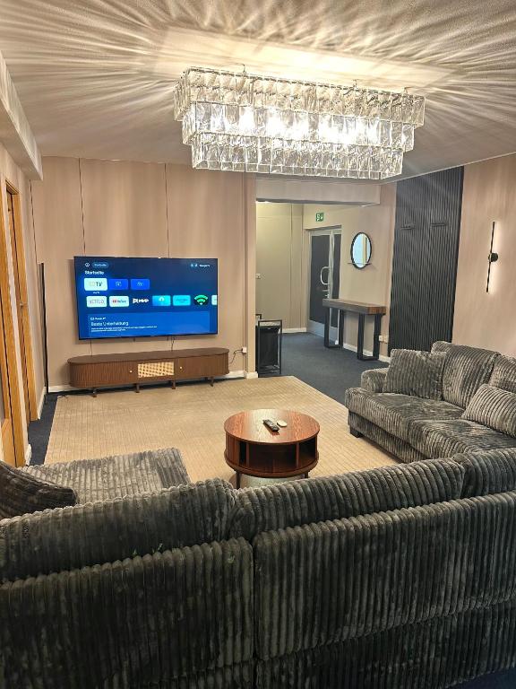 a living room with couches and a large screen tv at City Apartment Hamburg Work Relax Repeat in Hamburg