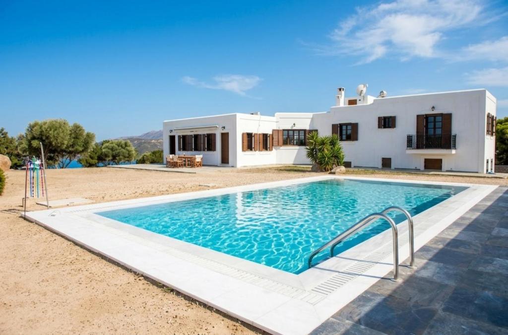 a large swimming pool in front of a house at My Way Kavos Villa in Agia Marina Aegina