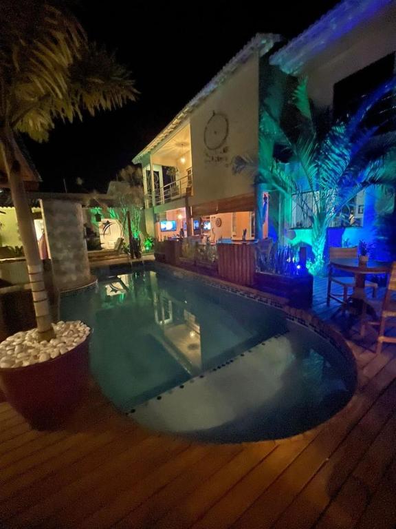 a swimming pool in front of a building at night at Pousada Macdonald in Eunápolis