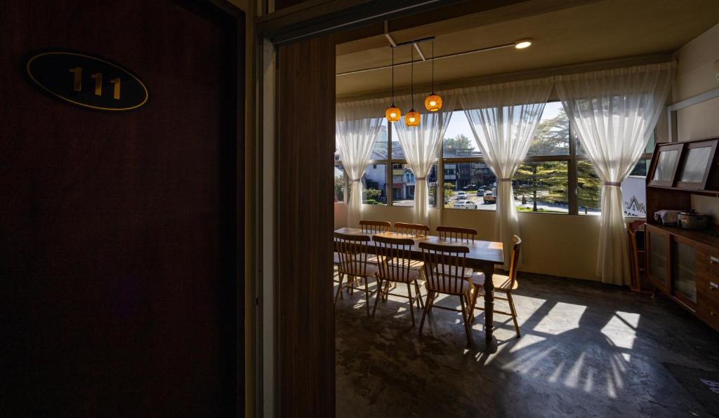 a dining room with a table and chairs and a window at The Cottage Stay - self check-in in Kuching
