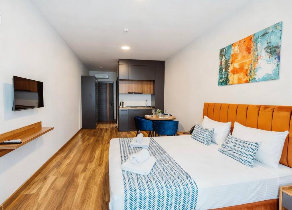 a bedroom with a large bed and a kitchen at Apartments in Navi in Gonio