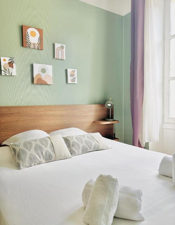 a bedroom with a bed with white sheets and pillows at La Carpe d'Or in Fontainebleau