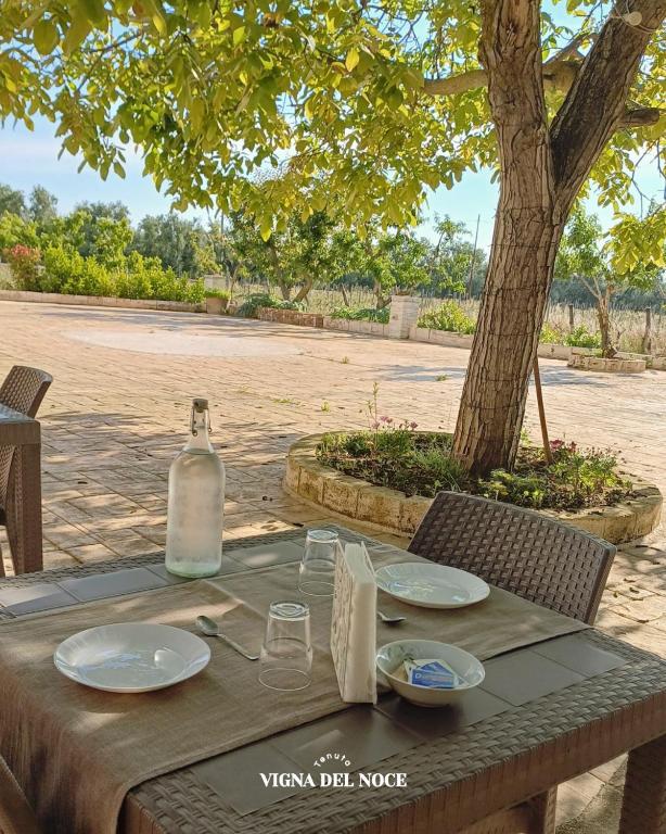 a picnic table with a bottle of wine on it at Tenuta Vigna del Noce in Corato