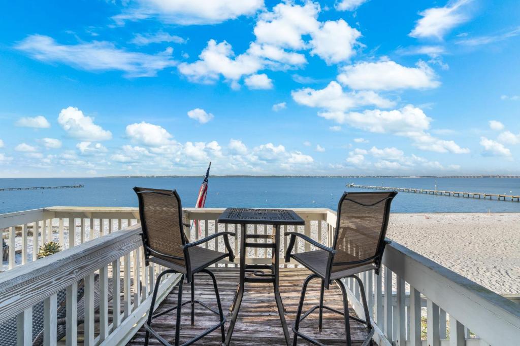 a table and two chairs on a balcony overlooking the beach at Boardwalk Unit E4 in Pensacola Beach