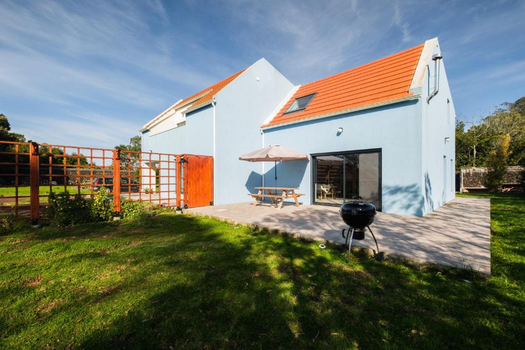 a house with an orange roof and a grill at FishTail Guest House in Rabo de Peixe