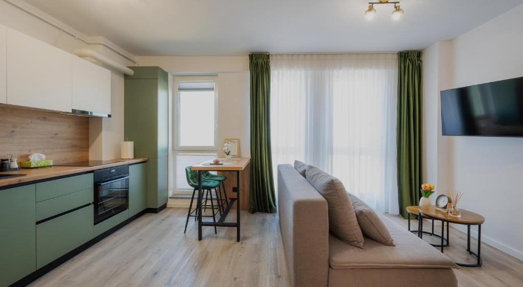 a living room with a couch and a kitchen at NXN Airportstay in Cluj-Napoca