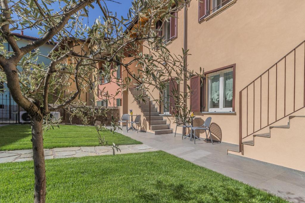 a building with chairs and a grass yard at Ca Magnolia Appartamento 3 in Lierna