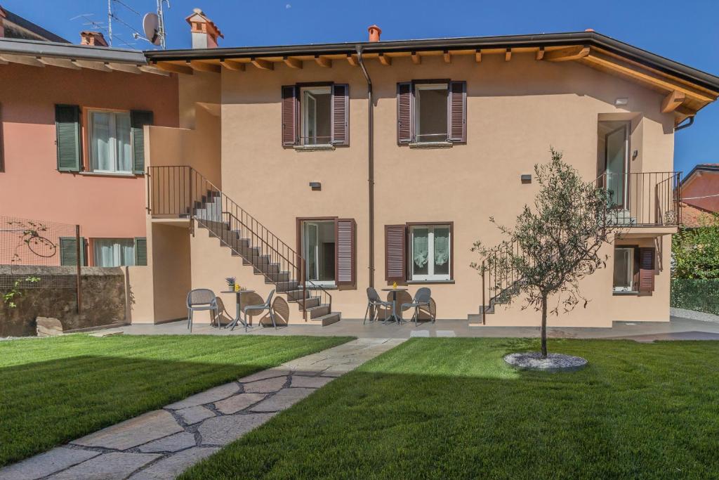 a house with chairs and a lawn in front of it at Ca Magnolia Appartamento 2 in Lierna