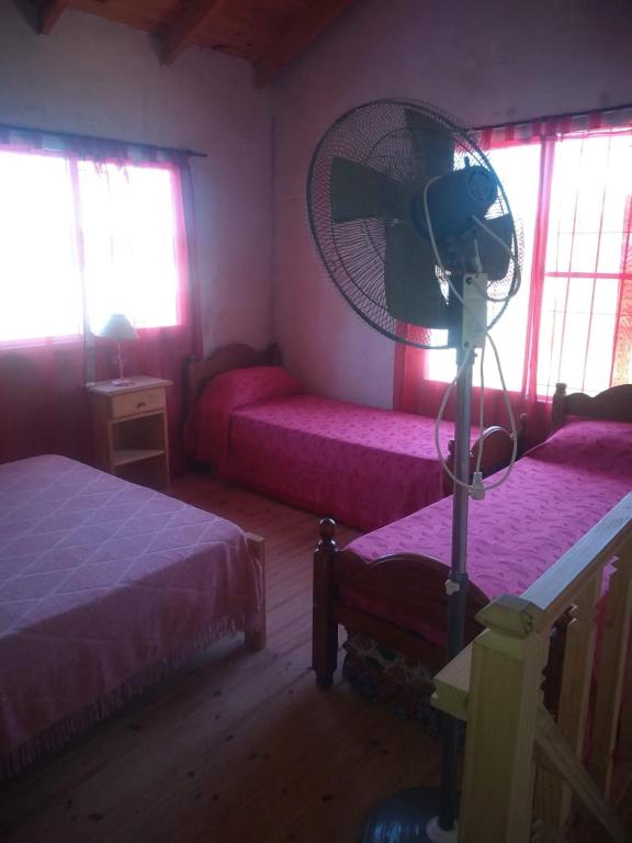 a bedroom with two beds and a fan at Casa Ibira pita in Pueblo Liebig