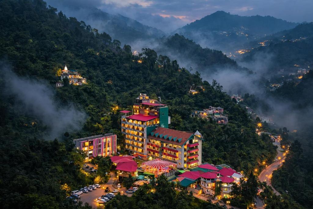 a large building on a mountain with a city at Hotel Royal Ark - Kasauli in Kasauli