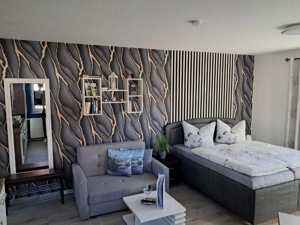 a bedroom with a bed and a couch and a chair at Ferienwohnung Luna in Stralsund