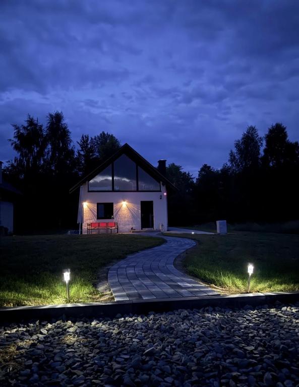 a house lit up at night with a stone path at Domek pod Besidą in Czarna
