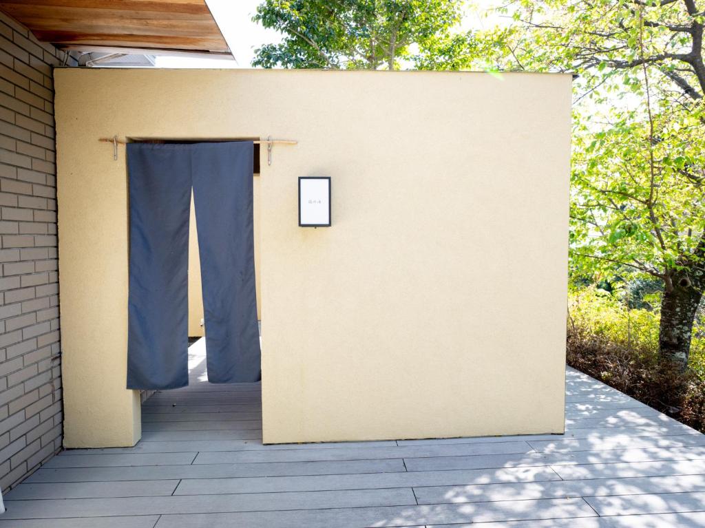 a building with a door with a blue curtain at バケーションイン伊豆高原 in Ito