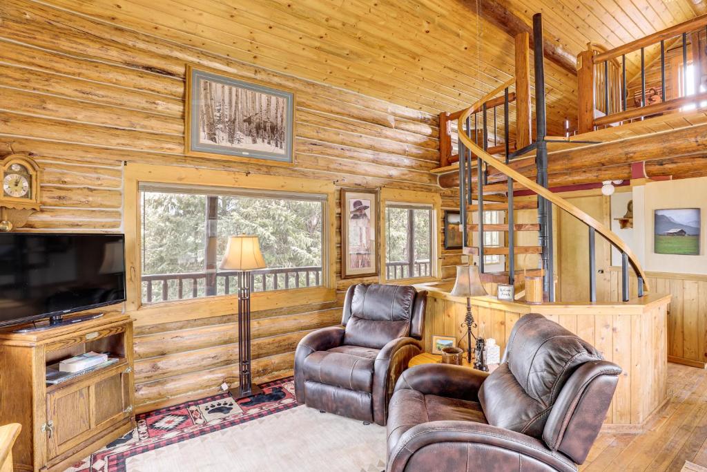 a living room with two chairs and a tv at Wild Adventures in Eureka! Amish-Crafted Cabin in Eureka