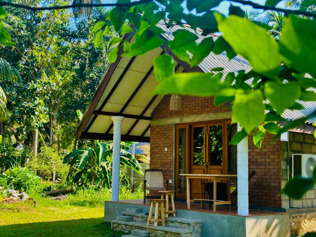 a small brick house with a porch and a table at Sigiriya Lahiru Homestay in Sigiriya