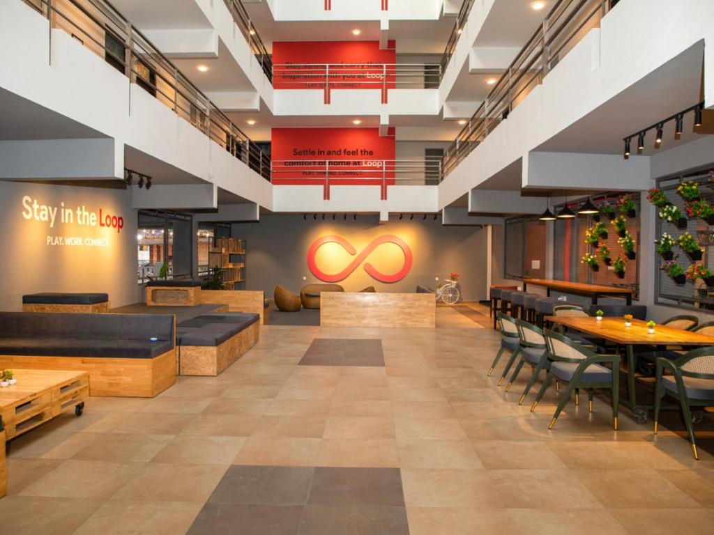 a restaurant with tables and chairs and a sign that says stay little loop at Z Stays, Silkboard in Bangalore