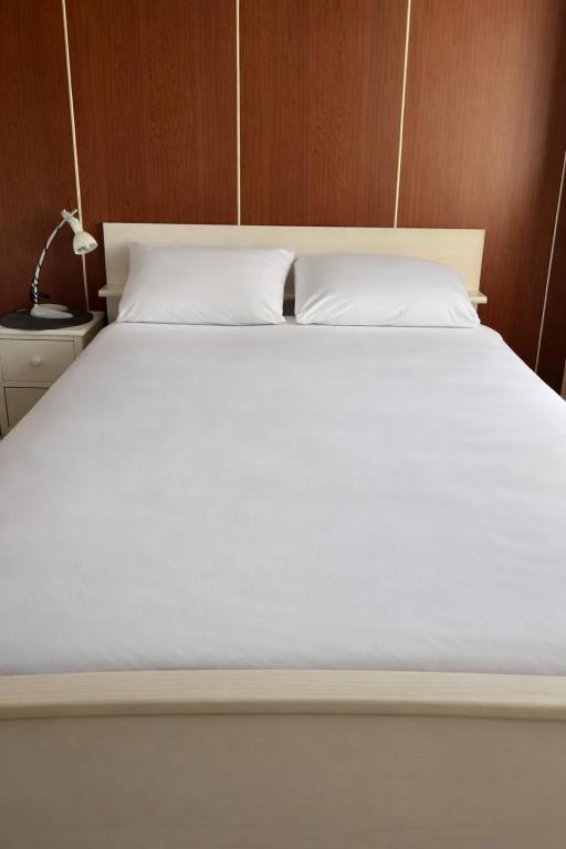 a bed with white sheets and pillows on it at Rustig verblijf bij de Rijn - Lobith in Lobith