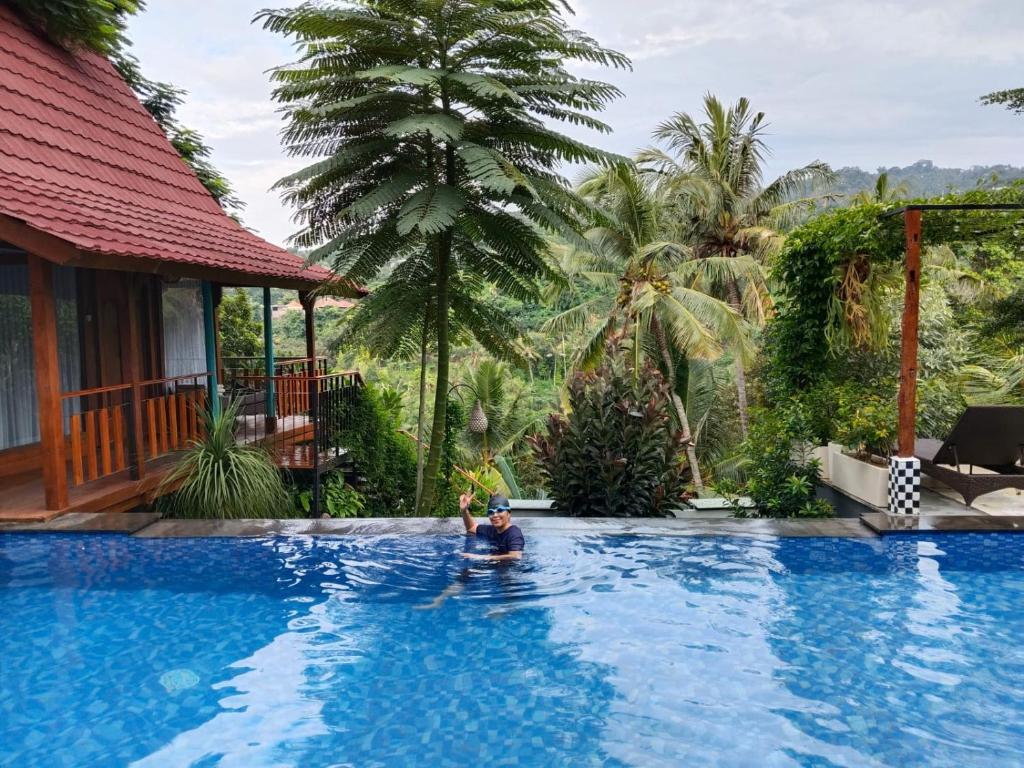 a man in a swimming pool at a resort at Aramaya Hills Boutique in Banjar