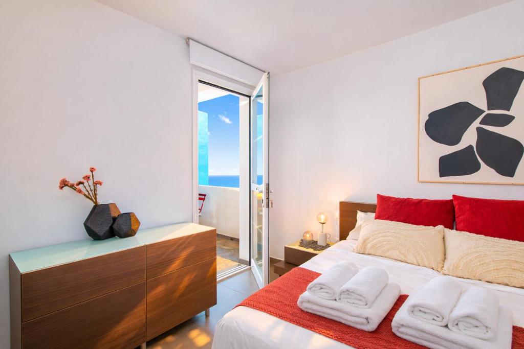 a bedroom with a large bed with red pillows at Profithome - Tabaiba Tenerife in Santa Cruz de Tenerife