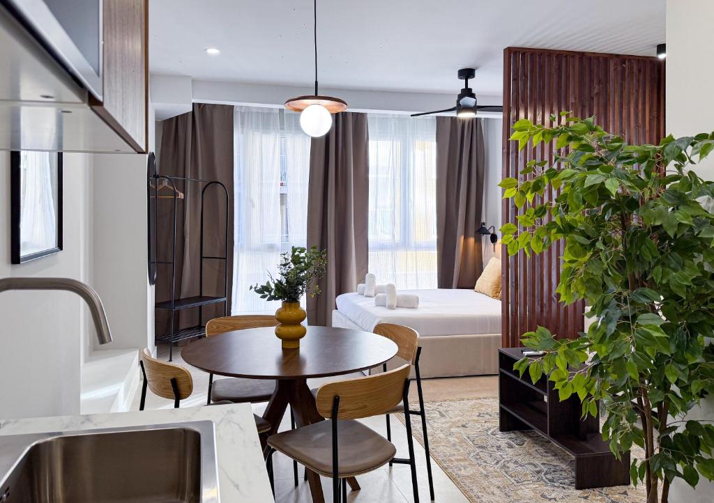 a living room with a table and a bedroom at Studios Mugakoa By Sahats in Portugalete