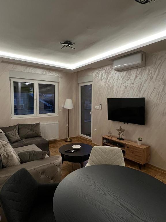 a living room with a couch and a flat screen tv at PRESTIGE apartman Krusevac in Kruševac