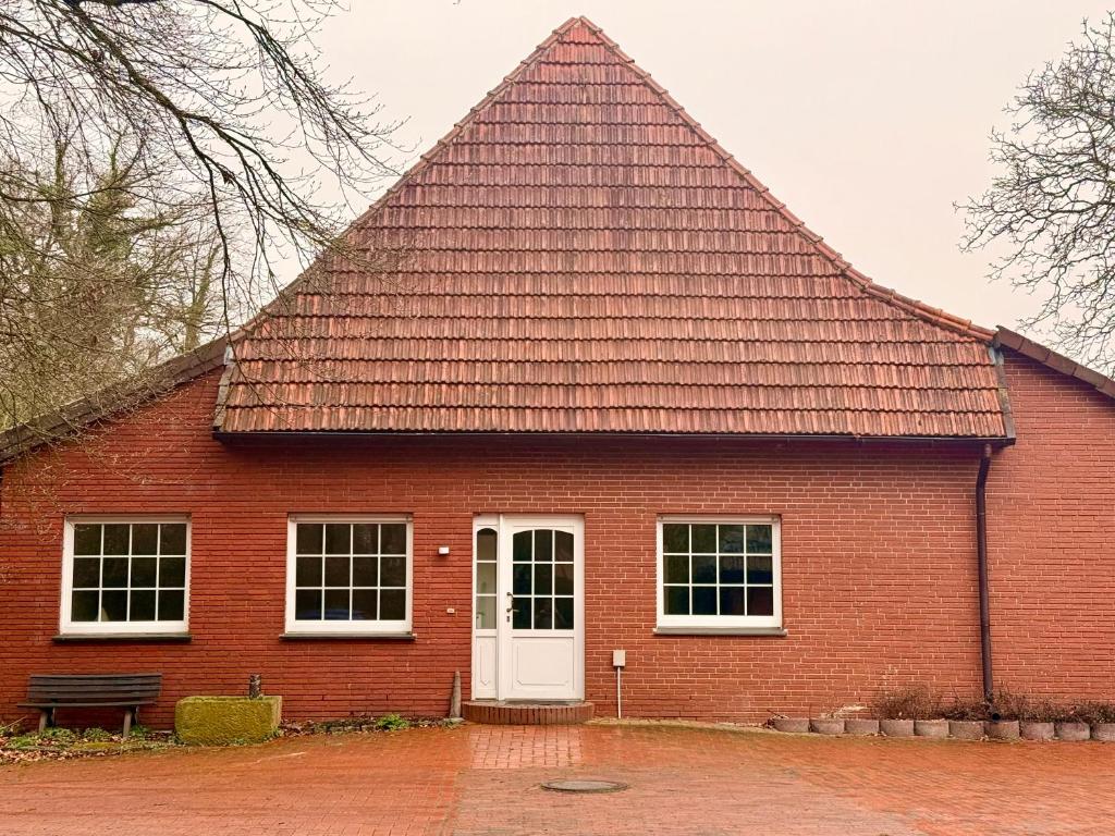 a red brick house with a large roof at Haus an der Hase in Bramsche