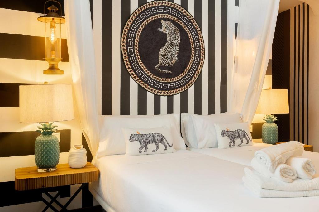 a bedroom with a white bed with black and white stripes at Abalú Collection Hotel Life Gran Via in Madrid
