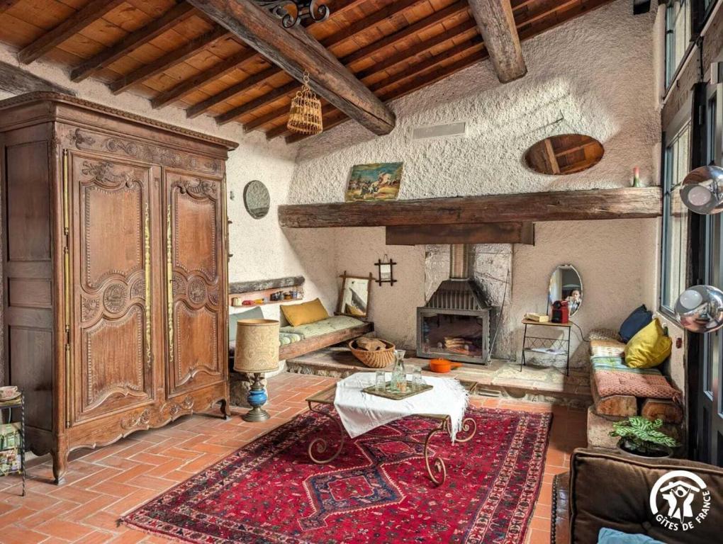 a living room with a table and a fireplace at Maison malouna in Saint-Thibéry